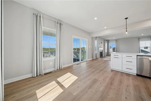 a open kitchen with white cabinets and wooden floor