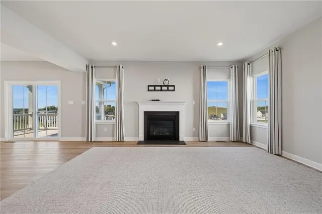 a view of an empty room with a fireplace and a window