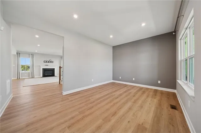 an empty room with wooden floor and fireplace