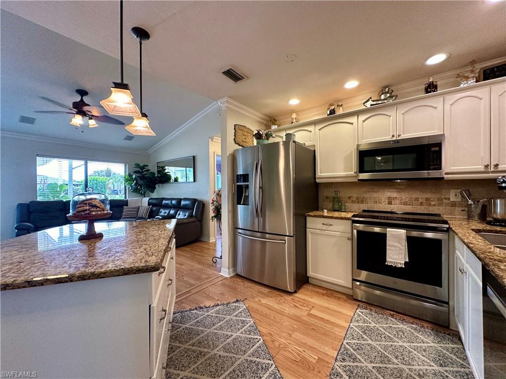 17444 Ingram Road Fort Myers, FL 33967 - Photo 4 of 27 Kitchen with light hardwood / wood-style flooring, stainless steel appliances, hanging light fixtures, crown molding, and ceiling fan