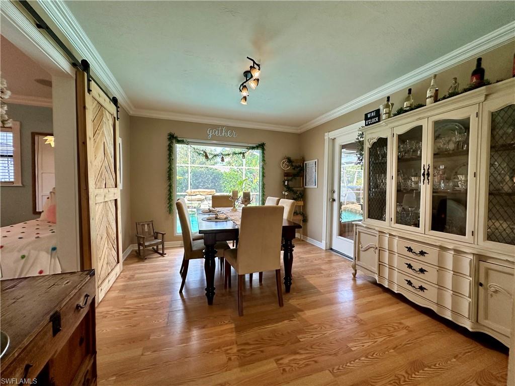 17444 Ingram Road Fort Myers, FL 33967 - Photo 8 of 27 Dining room with light hardwood / wood-style floors, ornamental molding, and a barn door