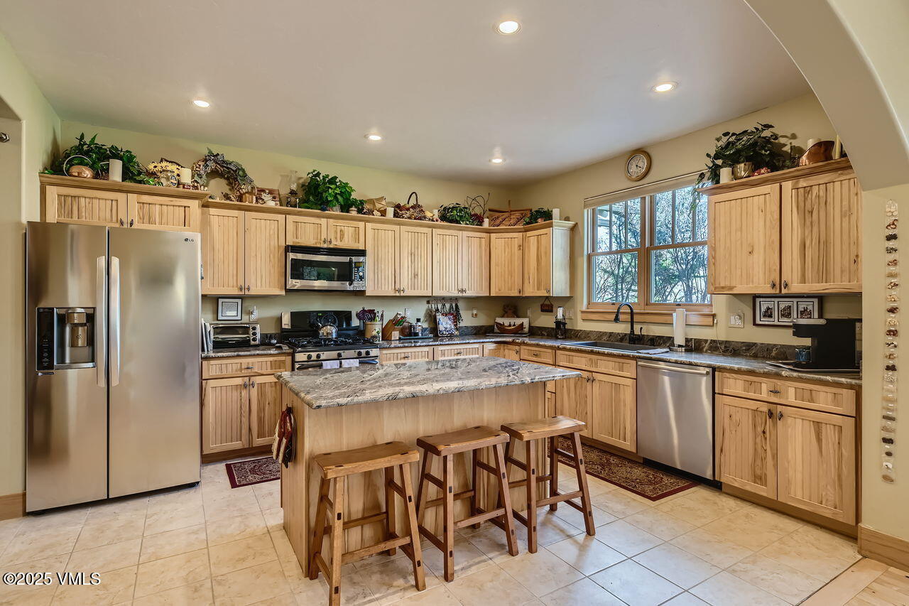 1987 Eagle Ranch Road Eagle, CO 81631 - Photo 11 of 37 a kitchen with refrigerator and chairs