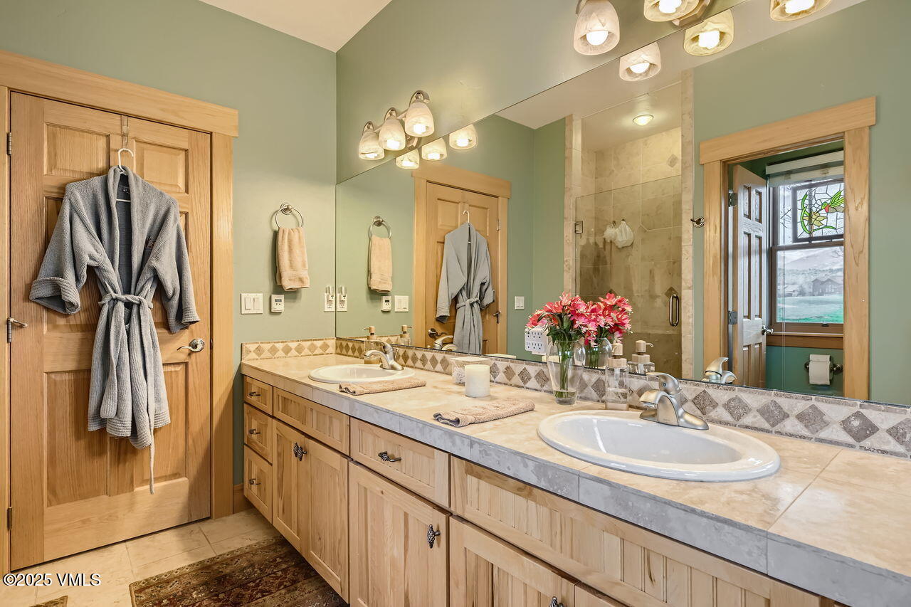 1987 Eagle Ranch Road Eagle, CO 81631 - Photo 21 of 37 a bathroom with a granite countertop sink a large mirror and a shower