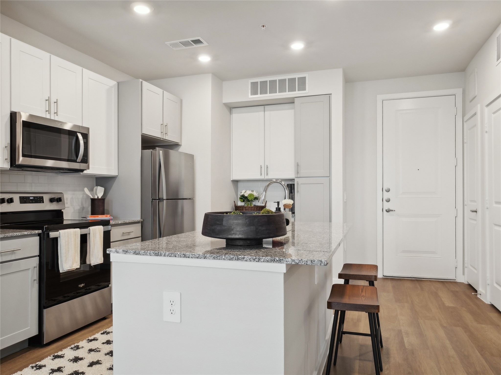 a kitchen with a refrigerator a stove and a microwave