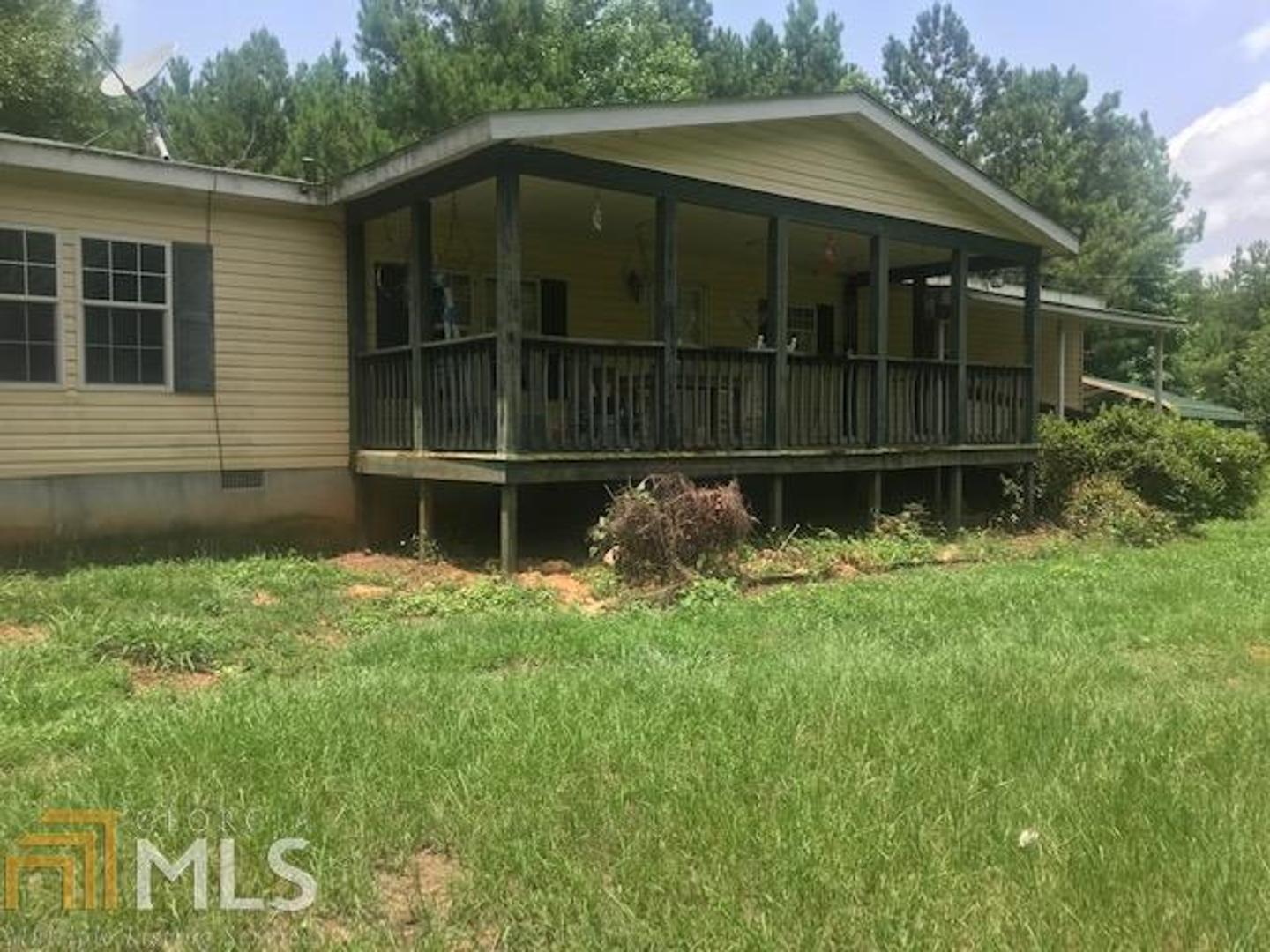 1401 Dixon Road Sparta, GA 31087 - Photo 1 of 1 a front view of a house with a garden