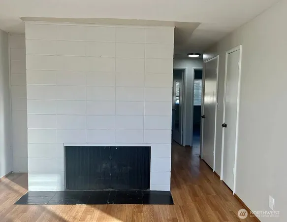 a living room with a fireplace and wooden floor