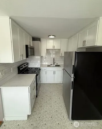 a kitchen with a refrigerator a stove top oven a sink and dishwasher