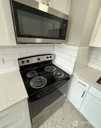a stove top oven sitting inside of a kitchen