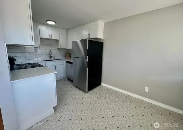 a kitchen with a refrigerator stove and cabinets