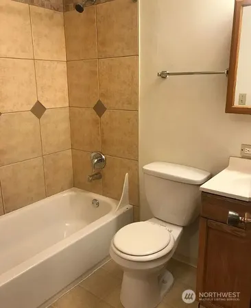 a white toilet and tub sitting next to a bathroom sink
