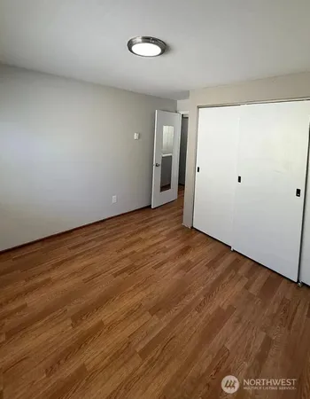 a view of an empty room with wooden floor