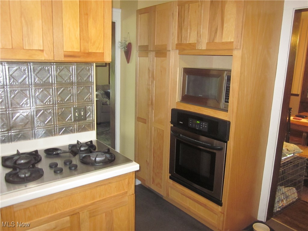 10035 Baltic Road Cleveland, OH 44102 - Photo 13 of 41 Kitchen featuring light brown cabinets, stainless steel microwave, decorative backsplash, and oven