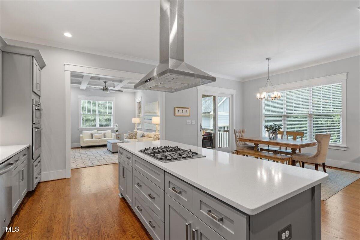 1215 Brookside Drive Raleigh, NC 27604 - Photo 13 of 34 a kitchen with stainless steel appliances a stove a sink dishwasher and white cabinets with wooden floor