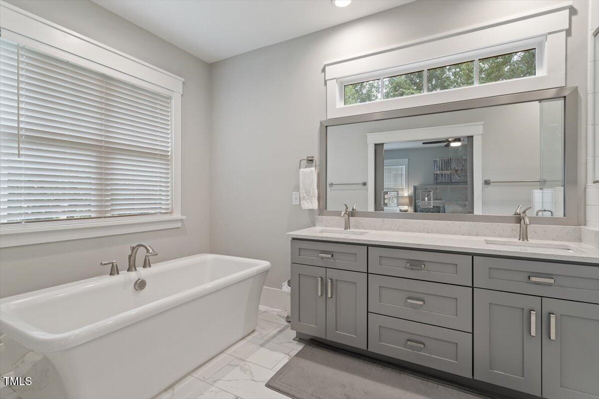 1215 Brookside Drive Raleigh, NC 27604 - Photo 24 of 34 a spacious bathroom with a double vanity sink mirror and a bathtub
