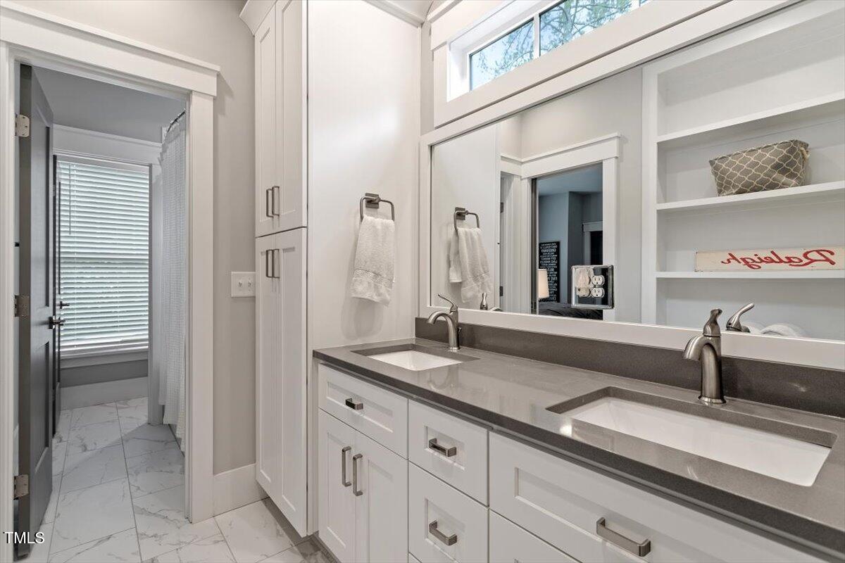 1215 Brookside Drive Raleigh, NC 27604 - Photo 28 of 34 a spacious bathroom with a granite countertop sink and a mirror