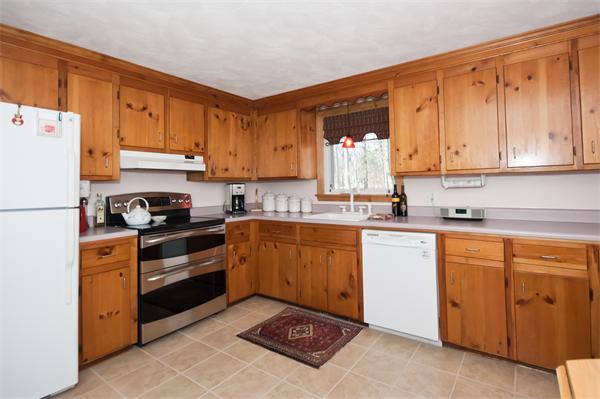 8 Michael Road Billerica, MA 01862 - Photo 3 of 10 a kitchen with granite countertop a refrigerator sink stove and white cabinets