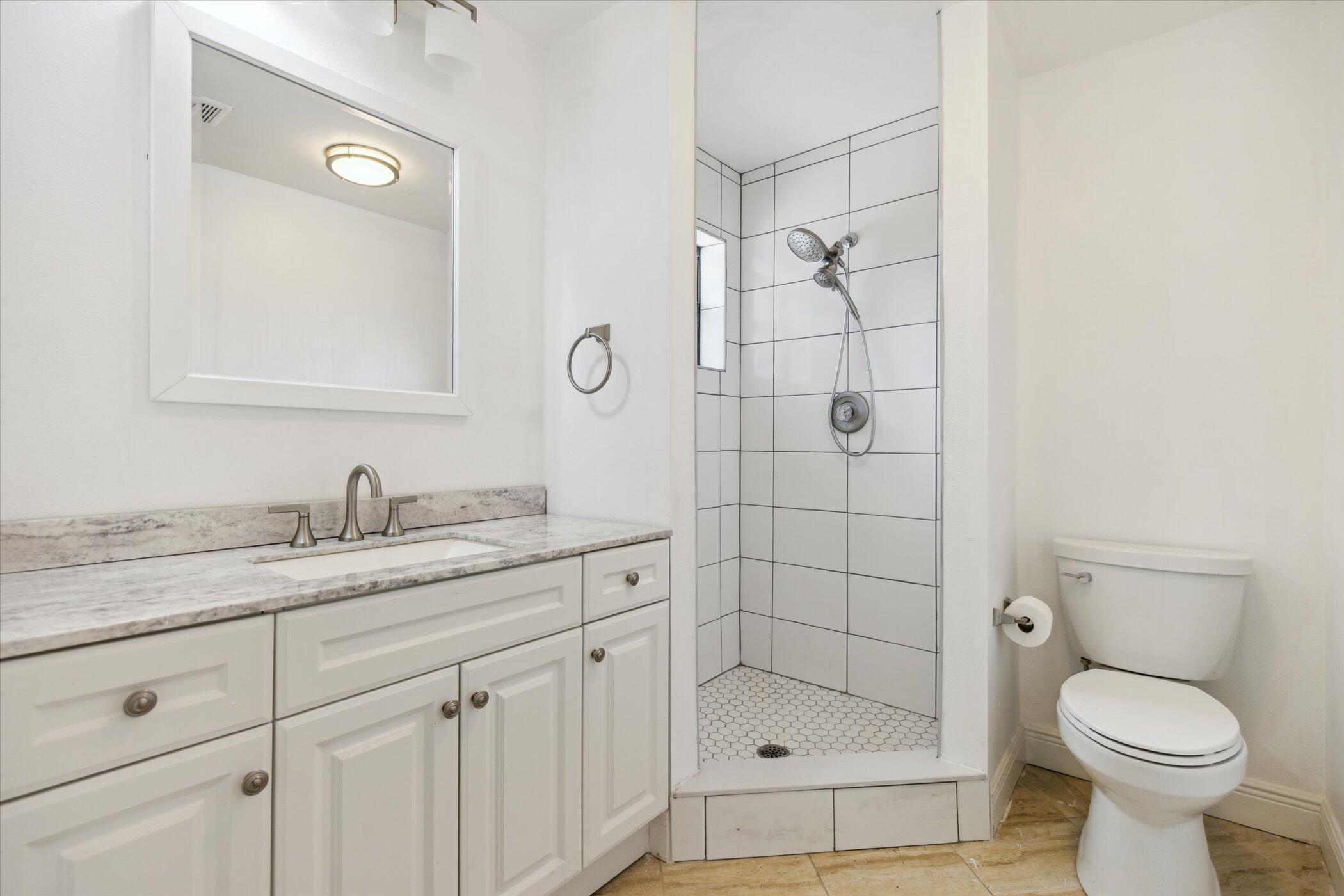 1045 Garden Road Merritt Island, FL 32952 - Photo 17 of 37 a bathroom with a granite countertop sink toilet and shower