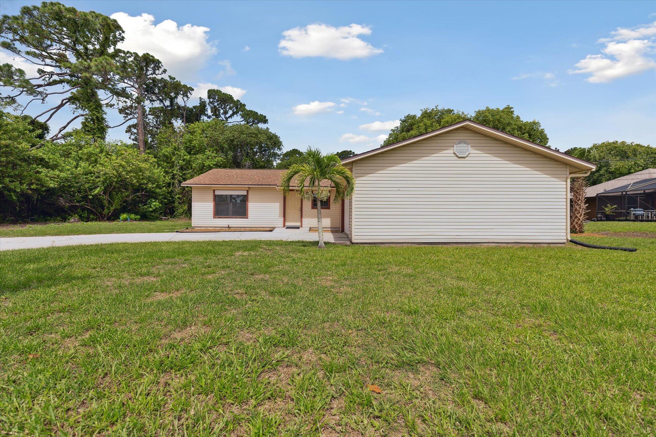 1045 Garden Road Merritt Island, FL 32952 - Photo 2 of 37 a front view of house with yard and trees in the background
