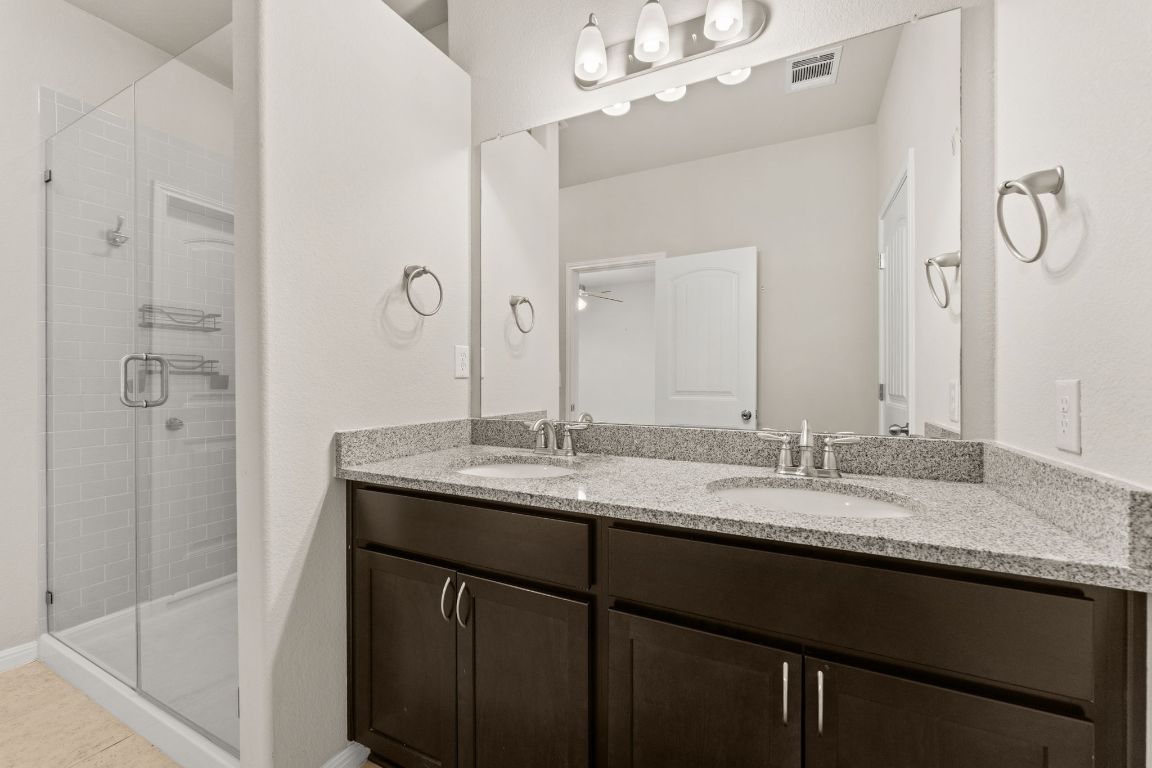 7709 Menchaca Road, Unit 5 Austin, TX 78745 - Photo 12 of 21 a bathroom with a granite countertop sink a mirror and shower