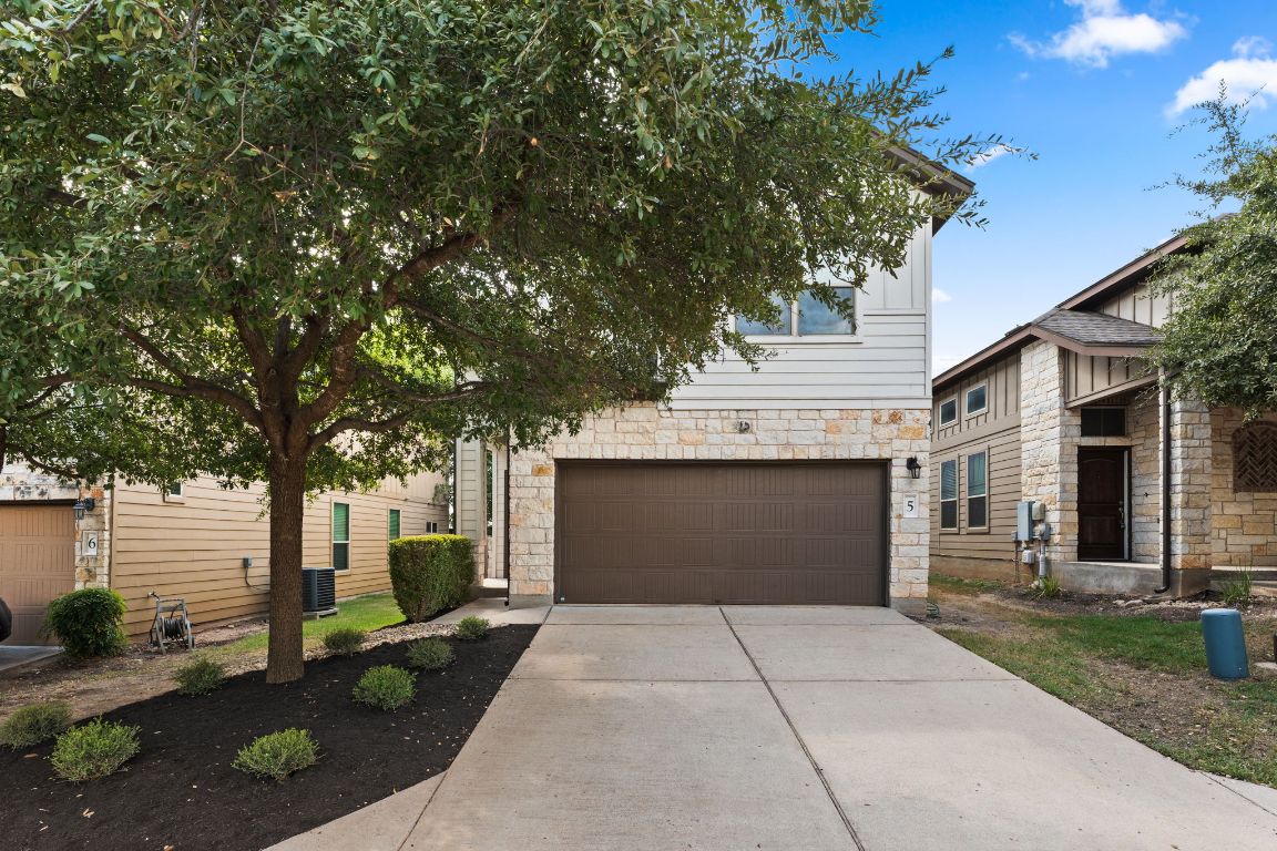 7709 Menchaca Road, Unit 5 Austin, TX 78745 - Photo 3 of 21 a front view of a house with a yard and a garage