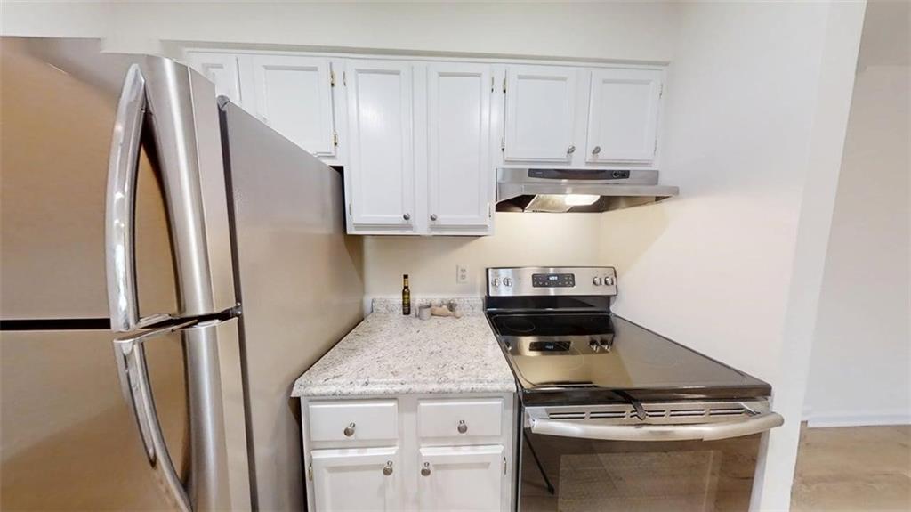 300 Johnson Ferry Road, Unit A312 Atlanta, GA 30328 - Photo 24 of 31 a kitchen with a stove and a refrigerator