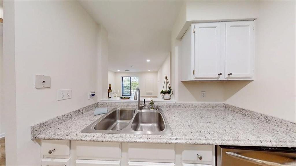 300 Johnson Ferry Road, Unit A312 Atlanta, GA 30328 - Photo 25 of 31 a kitchen with granite countertop a sink and a white stove