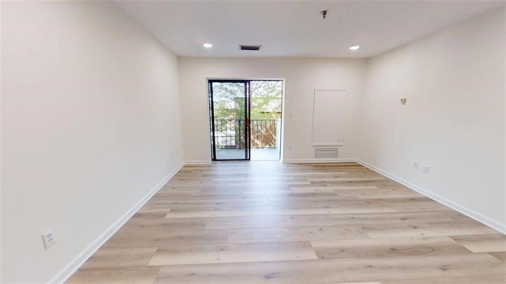 300 Johnson Ferry Road, Unit A312 Atlanta, GA 30328 - Photo 30 of 31 a view of an empty room with wooden floor and a window
