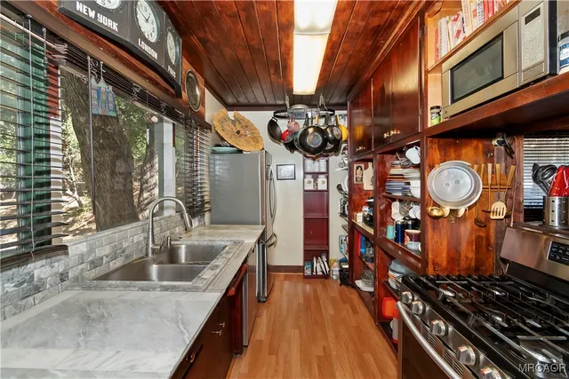 a kitchen with stainless steel appliances granite countertop a sink a stove oven a counter space and cabinets