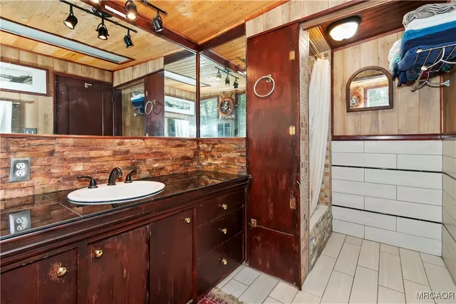 a bathroom with a granite countertop sink and a large mirror