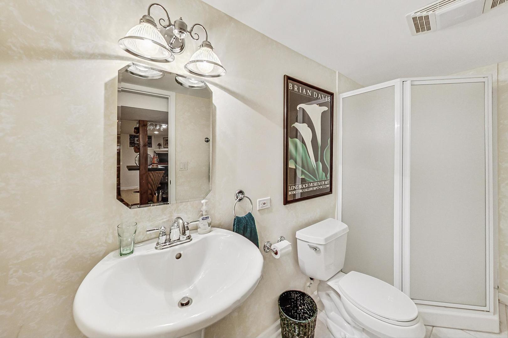 1016 Midway Road Northbrook, IL 60062 - Photo 19 of 27 a bathroom with a toilet a sink a mirror and vanity