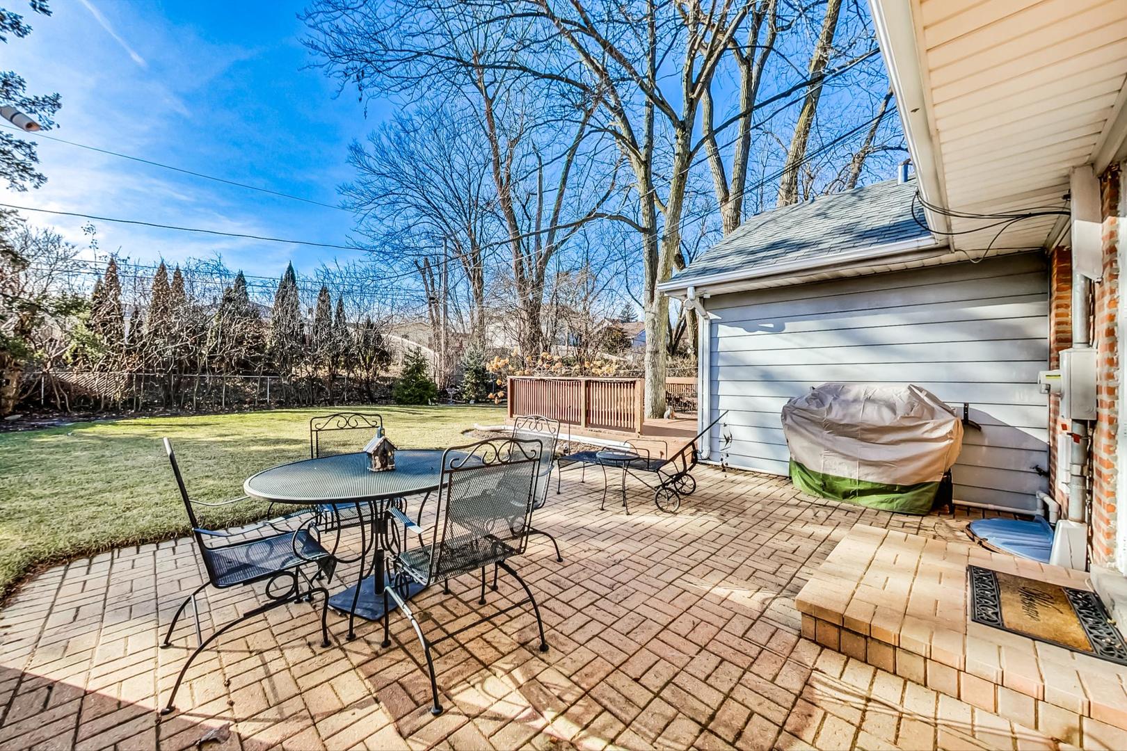 1016 Midway Road Northbrook, IL 60062 - Photo 21 of 27 a view of a backyard with table and chairs potted plants and a fire pit