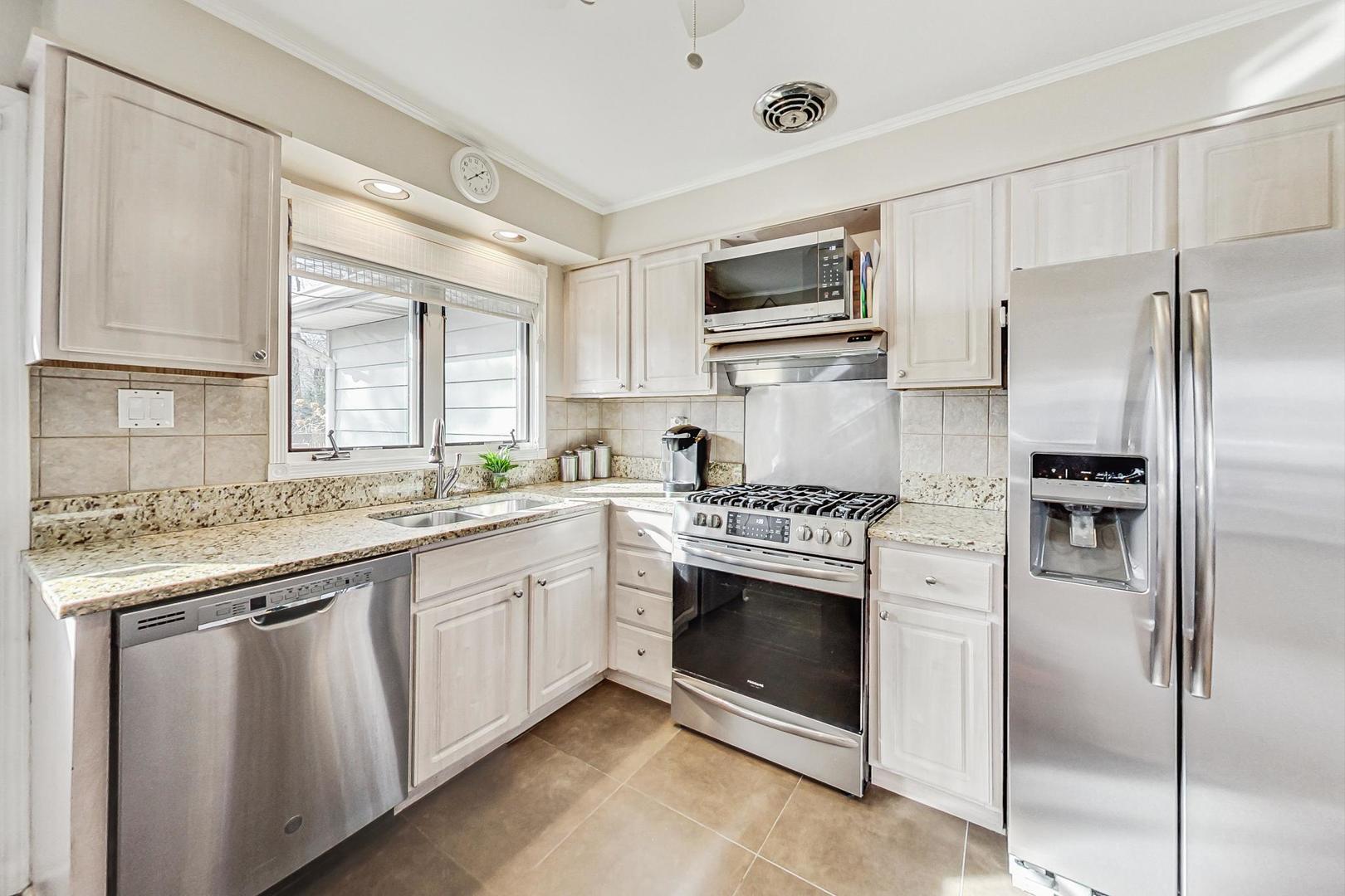 1016 Midway Road Northbrook, IL 60062 - Photo 7 of 27 a kitchen with stainless steel appliances granite countertop a stove a sink and a refrigerator