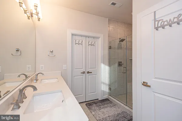 a bathroom with a shower sink vanity mirror and toilet