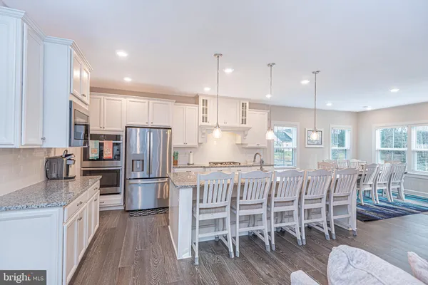 a large kitchen with kitchen island a stove a sink a oven and a dining table