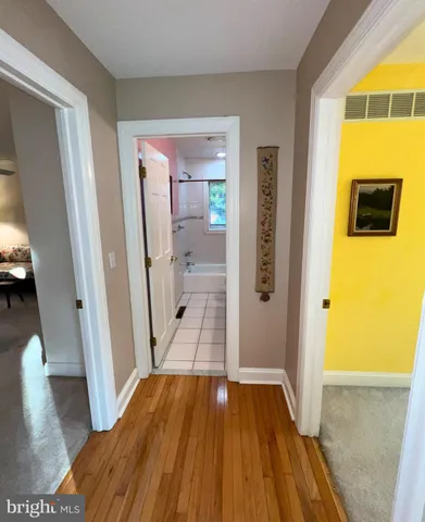 a view of a hallway view with wooden floor and living room