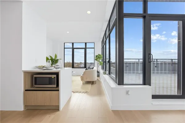 a living room with stainless steel appliances a large window