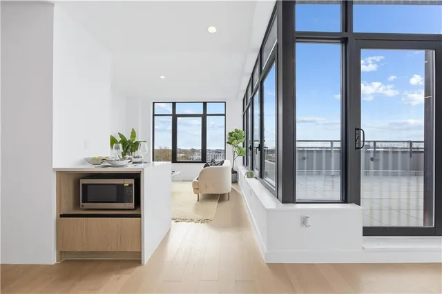 a living room with stainless steel appliances a large window
