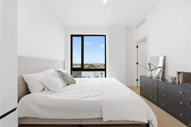 a bedroom with a large bed and a window