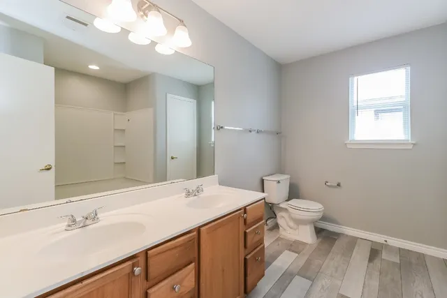 a view of empty room with wooden floor and ceiling fan