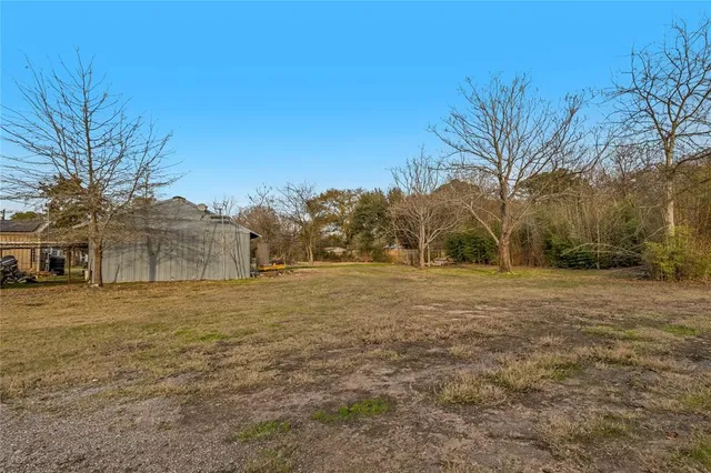 a view of dirt field with trees