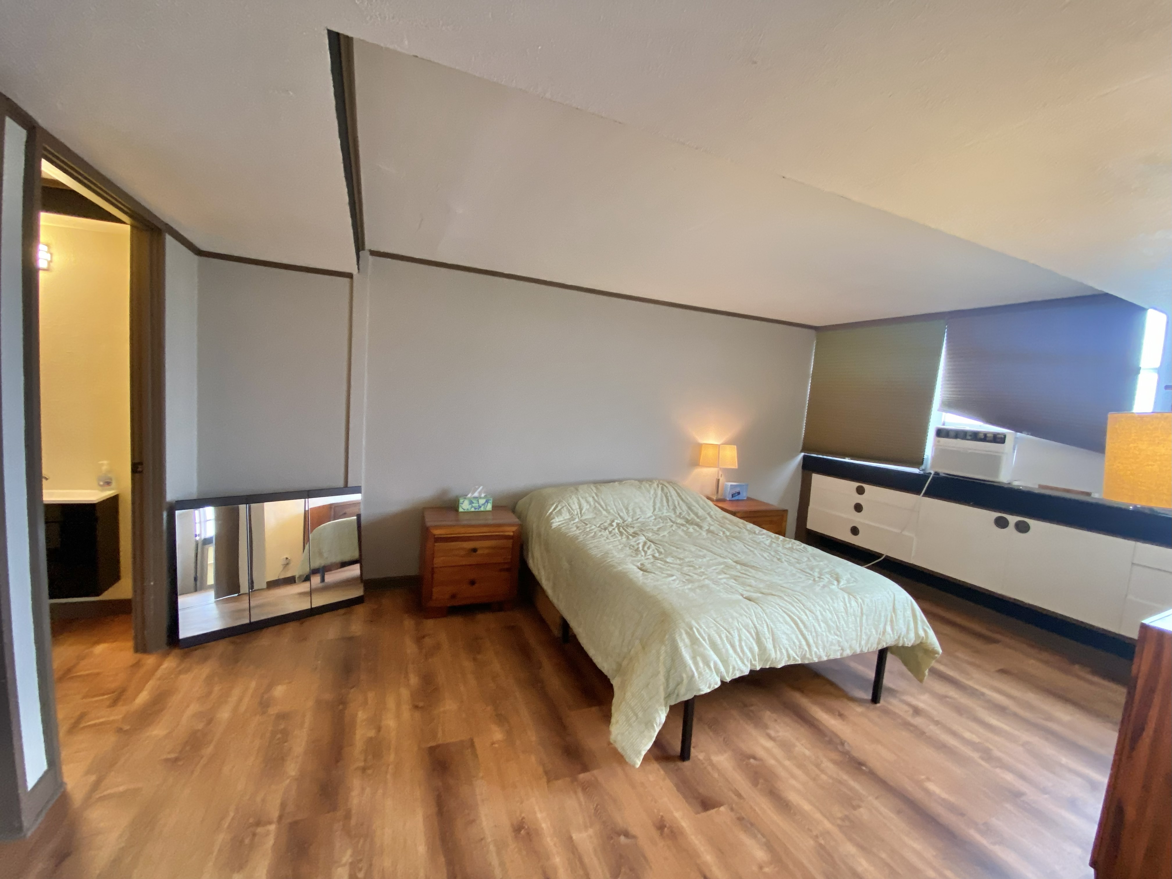 84 Pukihae Street, Unit PH6 Hilo, HI 96720 - Photo 19 of 29 a bedroom with a bed and a dresser with wooden floor