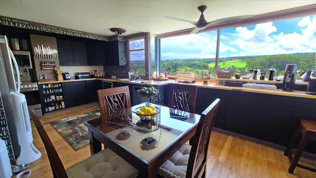 a kitchen with a stove a sink and a dining table with garden view