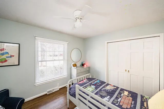 a bedroom with a bed and wooden floor