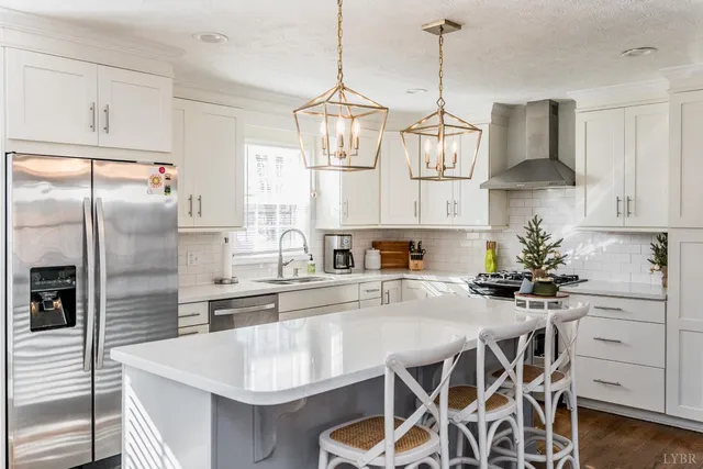 a kitchen with stainless steel appliances granite countertop a sink a refrigerator and a stove