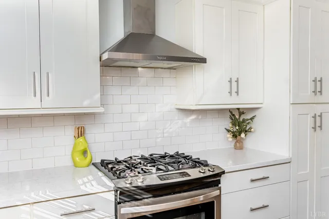 a kitchen with stainless steel appliances a sink a counter cabinets and a window