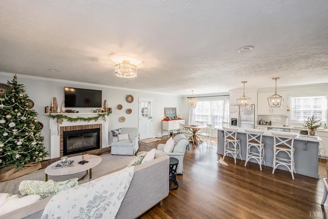 a living room with fireplace furniture flat screen tv and wooden floor