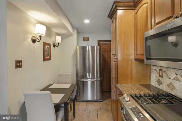 a kitchen with stainless steel appliances granite countertop a refrigerator and a stove top oven