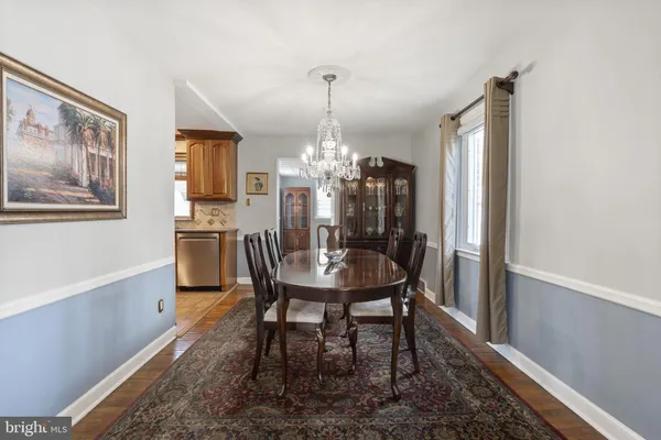 a dining room with furniture a chandelier and wooden floor