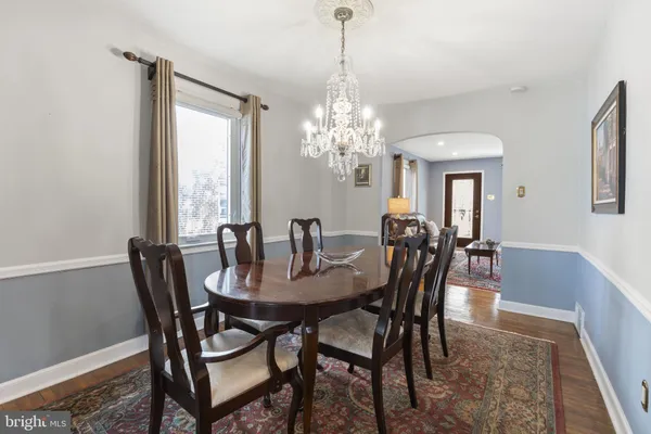 a dining room with furniture a chandelier and window