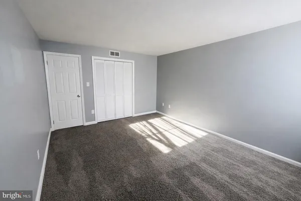 a view of a big room with closet and wooden door